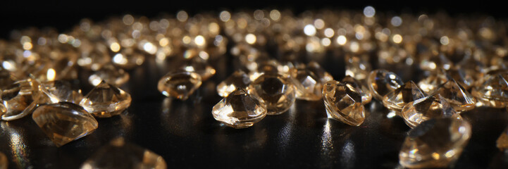 Bright diamonds scattered on dark table leaving reflection