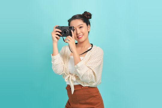 Young girl with camera isolated over blue background