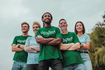 Five volunteers in uniforms standing in formation and smiling for the camera