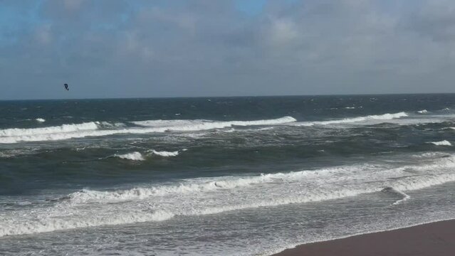 Kite Surfing at British Beach of England. High angle Drone's Camera Footage in Strong Winds and High Waves over Ocean