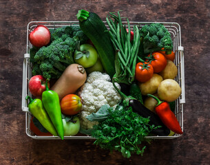 Basket with an abundant autumn seasonal harvest of vegetables - pumpkin, cauliflower, broccoli,...