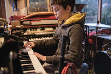 A 10-year-old child showcases his talent, passionately playing the organ in a rehearsal room,...