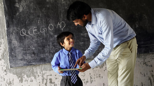 Young male lecturer helping student during his class. Student in a lecture with helpful teacher.
