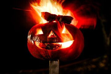 Halloween pumpkin fire smile and scary eyes for party night. View of scary Halloween pumpkin with fire eyes. Soft focus