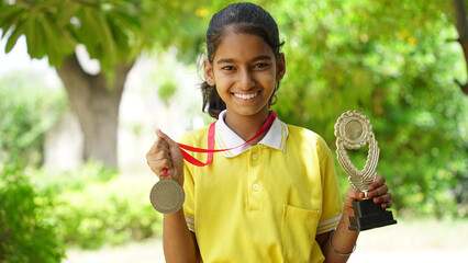 Excited Indian student school child wearing school uniform holding victory trophy in hand, Education concept.