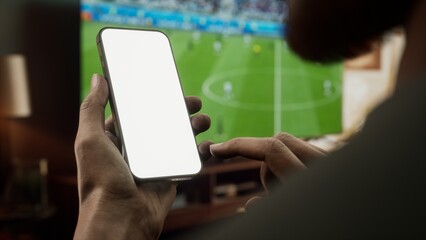 CU Black African-American male watching soccer at home, making bets on his phone