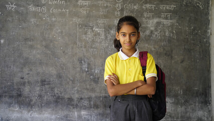 Indian schoolgirl sitting at desk in classroom, group of school kids with notebooks writing test, Education concept.