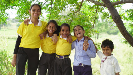 Happy Cute Smiling Rural or Village school kids in uniform standing. Friendship, Education and Togetherness Concept