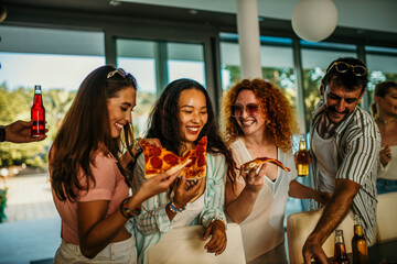 Diverse group of friends enjoying a lively day in a vibrant house party, savoring delicious pizza slices and refreshing beverages