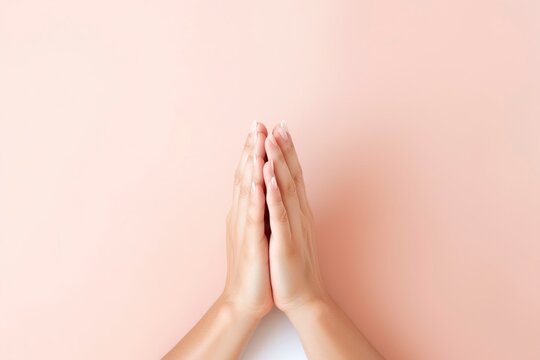Close-up of two hands with palms together, as if in prayer, on isolated background.