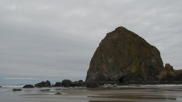 Haystack Rock beach in coastal town Cannon Beach, Oregon. Cloudy day