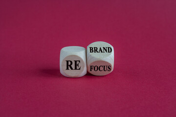 Refocus and rebrand symbol. Turned a cube and changed the word refocus to rebrand. Beautiful red background. Business, refocus and rebrand concept. Copy space.