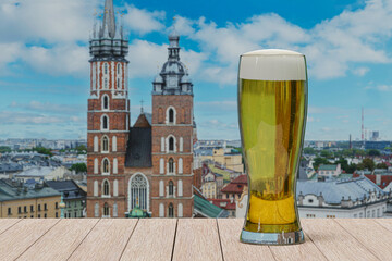 Glass of light beer on table in front of St. Mary's Basilica in Krakow, Poland
