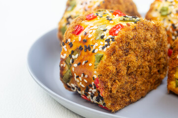 roti gulung abon or floss roll bread. contains shredded meat topped with sesame, spring onions and chili.
