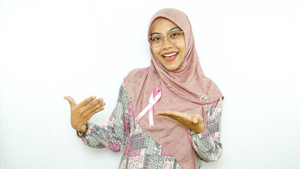 young asian woman patient showing pink badge ribbon chest to support breast cancer cause campaign.