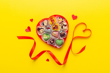 Valentine day composition: sweet candy, with gift boxes with bow and red felt hearts, photo...