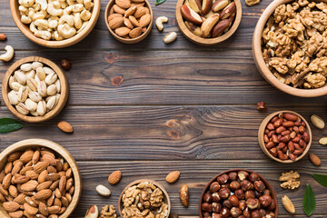 mixed nuts in wooden bowl. Mix of various nuts on colored background. pistachios, cashews, walnuts, hazelnuts, peanuts and brazil nuts