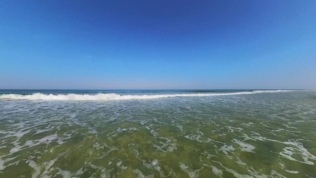 sanft brechende Wellen im klaren seichten Wasser, wundersch&ouml;ner einsamer menschenleerer Sandstrand, Horizont, Brandung, Wellen
