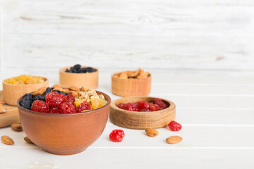 Cooking a wholesome breakfast. Granola with Various dried fruits and nuts in a bowl. The concept of a healthy dessert. Flat lay, top view with copy space