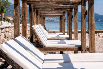 Wooden sunbeds in Orebic empty beach, Peljesac peninsula, Croatia