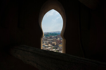 Cairo city view framed with the window of the minaret tower of Sultan Qansuh Al-Ghuri Complex,...
