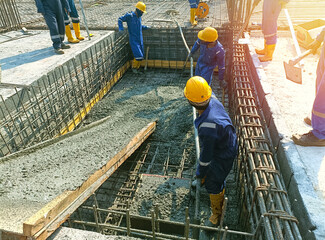 Workers concrete casting work. using concrete vibrator for compacting concrete of stiff consistency - obrazy, fototapety, plakaty