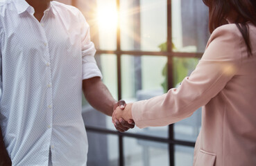 Manager greeting new employee and smiling in office