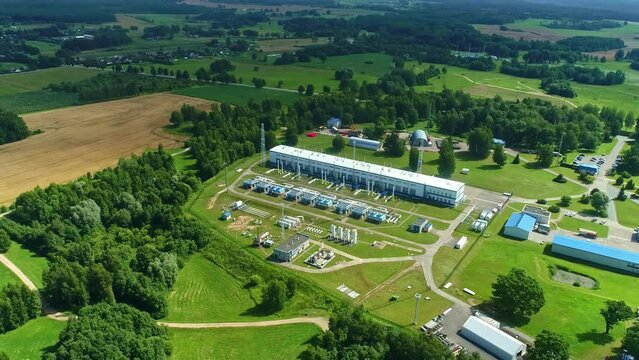 Aerial view tilting away from a Natural gas compressor station, sunny, summer day