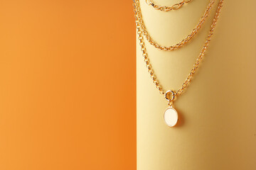 Golden chain with a pendant on yellow sheet of paper