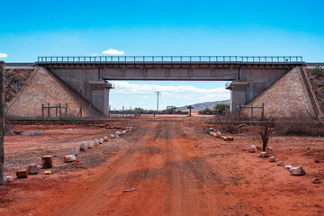 Obraz premium A dirt road passing below a railway line at Tsavo National Park in Kenya