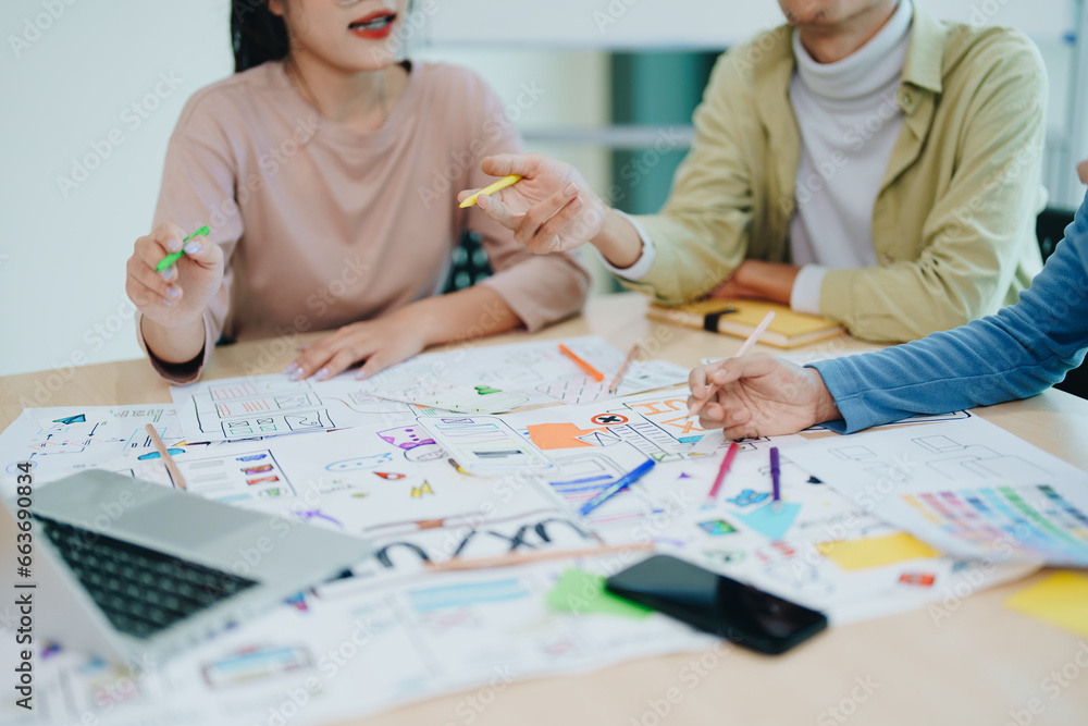 Wall mural group of asian creative team programing designers participate in all phases of the ux ui design.