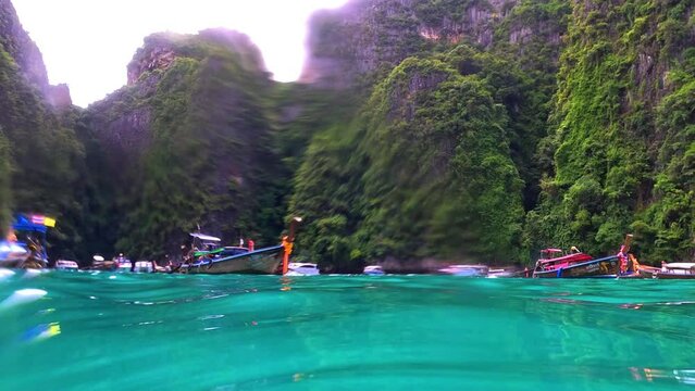 Phi Phi island off the coast of phuket thailand. Phi phi island is famous for turquoise clear blue waters teaming with Corel reef fish white soft sand and lush green trees.