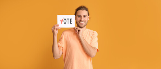 Happy man holding paper with text VOTE on orange background