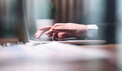 Close up of male hands while typing on laptop