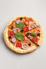 Board of tasty pizza with basil and tomatoes on grey background