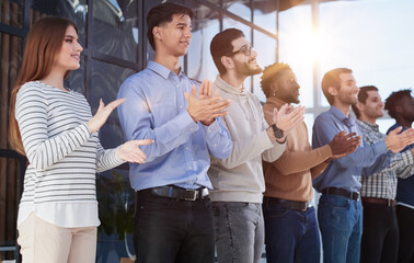 Smiling multiethnic colleagues celebrating common business success or victory in the office.