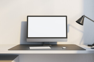Close up of modern workplace with empty white mock up computer monitor and lamp. 3D Rendering.