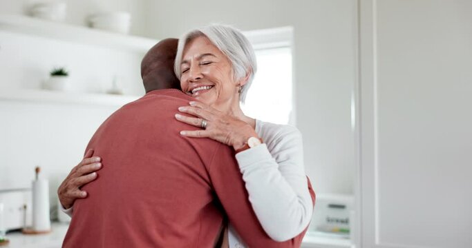 Interracial, couple and hug with trust and support at home, comfort with empathy or hello, love and old people. Retirement, life partner with black man and woman in marriage with embrace in kitchen