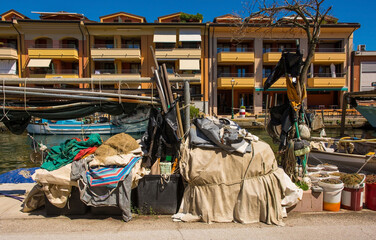 Fishing equipment lines a road on the waterfront of Grado in Friuli-Venezia Giulia, north east Italy. August - obrazy, fototapety, plakaty