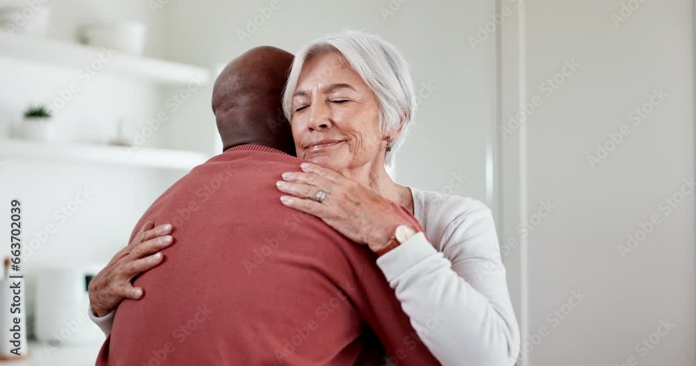 Wall mural Interracial, people and hug with love and support at home, comfort with empathy or hello, peace and old couple. Retirement, life partner with black man and woman in marriage with embrace in kitchen