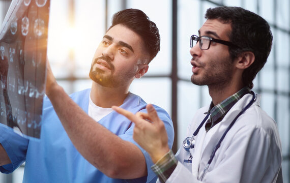 Two male doctors looking at brain x-ray