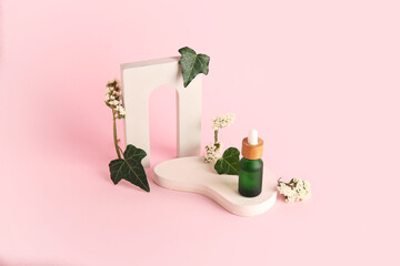Composition with bottle of essential oil, plaster podium and beautiful flowers on pink background