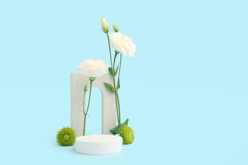 Composition with plaster podium and beautiful flowers on blue background