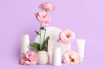 Composition with different cosmetic products, plaster podium and beautiful eustoma flowers on purple background