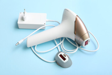 Charger and attachment for modern photoepilator on blue background
