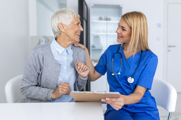 Young woman doctor or GP in white medical uniform consult female patient in private hospital....