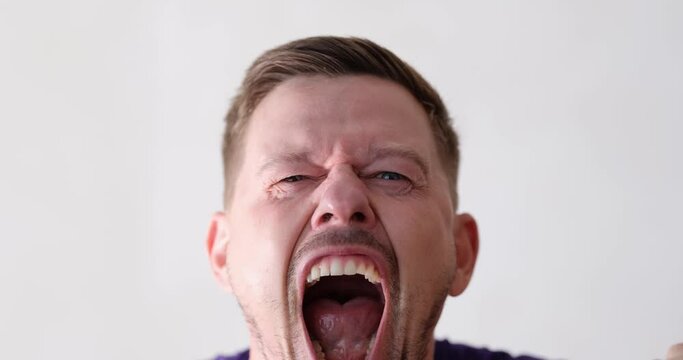 Irritated emotional man screaming with furious look. Young man feeling angry stress and bad mood concept