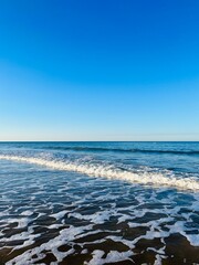 Blue sea horizon, sandy shoreline, natural blue seascape background