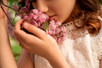 young woman smell pink flowers of  blooming apple tree on branch in spring - obrazy, fototapety, plakaty