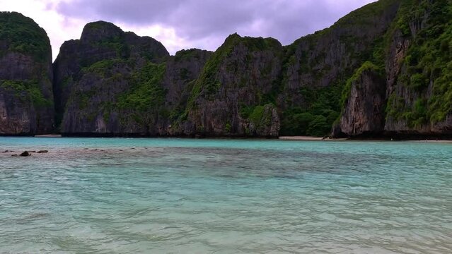 Phi Phi island off the coast of phuket thailand. Phi phi island is famous for turquoise clear blue waters teaming with Corel reef fish white soft sand and lush green trees.